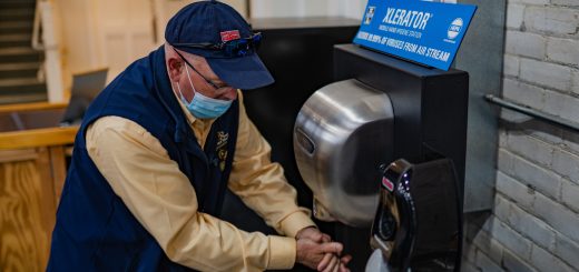 A man uses the XLERATOR Mobile Hand Hygiene Station