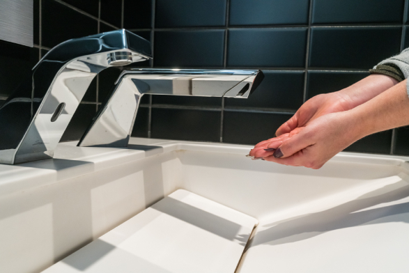 hands under a touchless sink system