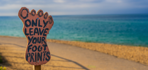 Beach with Only Leave Your Footprints sign in front of it