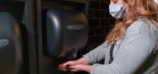 Woman using an XLERATOR dryer