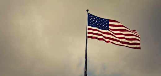 An American Flag in the wind in front of a grey sky