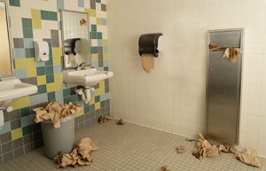 Restroom with paper towel trash all over the floor